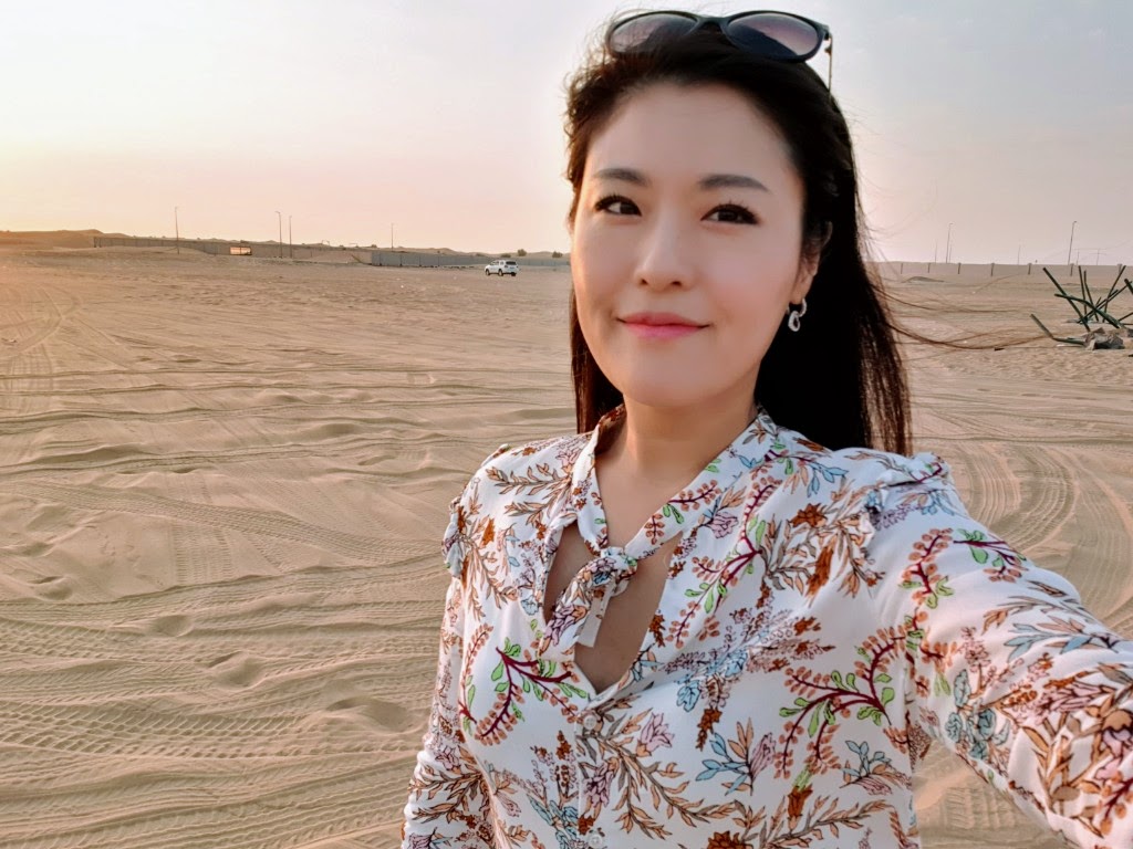 Min smiling in front of a desert landscape